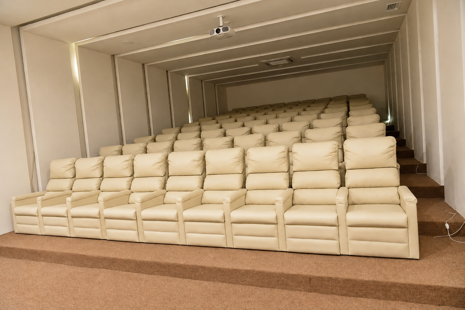 Sala de cinema com poltronas reclináveis e projeção