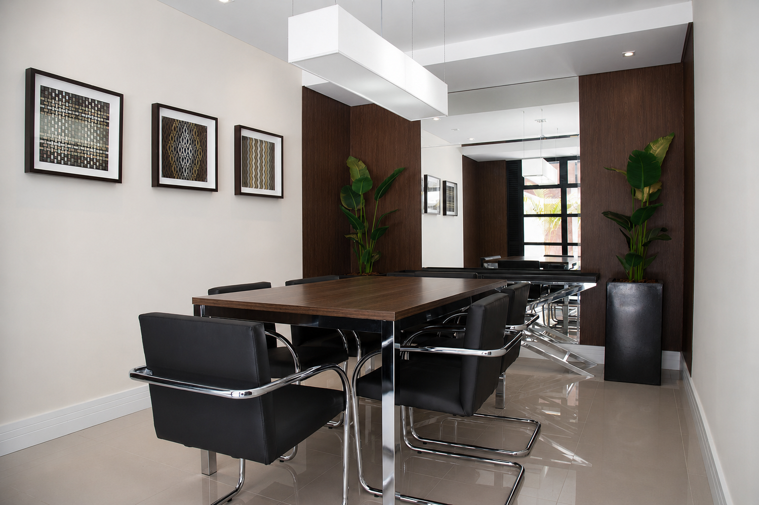 Sala de reunião com mesa ampla, cadeiras e marcenaria em madeira
