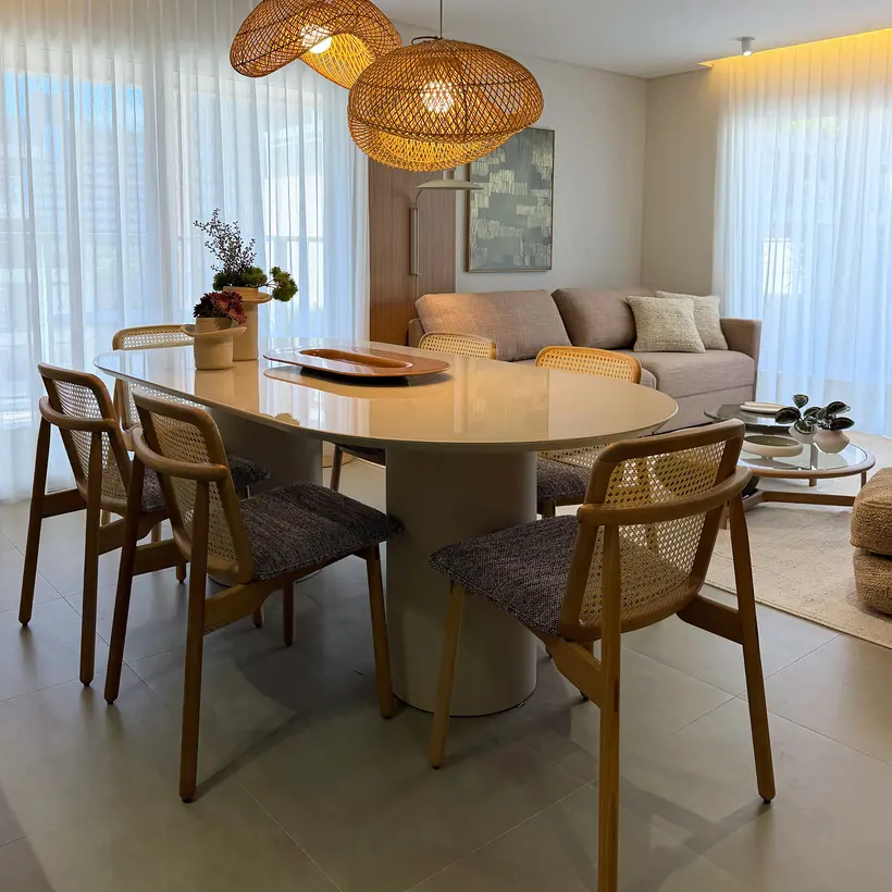 Estar e jantar integrados com mobiliário em madeira e iluminação decorativa