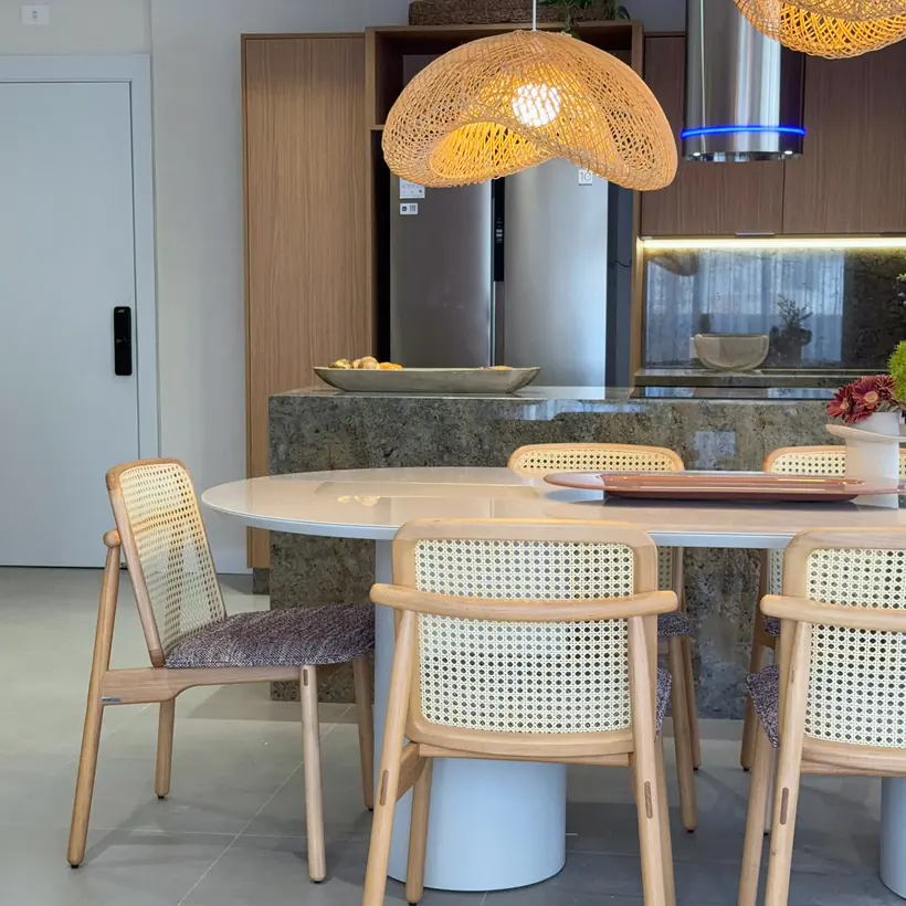 Sala de jantar integrada à cozinha com cadeiras em madeira e palhinha