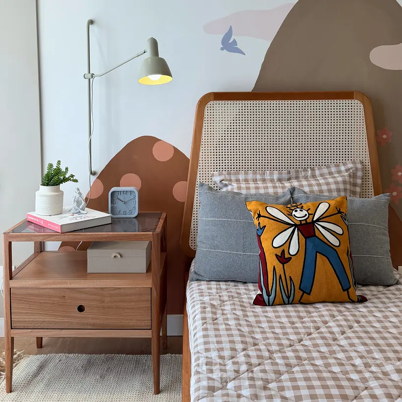 Quarto infantil com cama em palhinha, mesa lateral e pintura artística