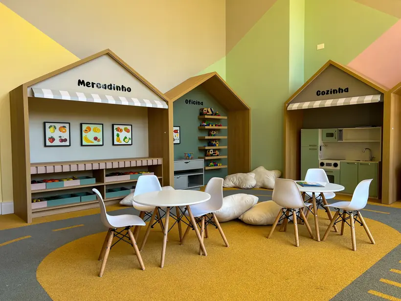 Espaço infantil com mesas e mobiliário lúdico