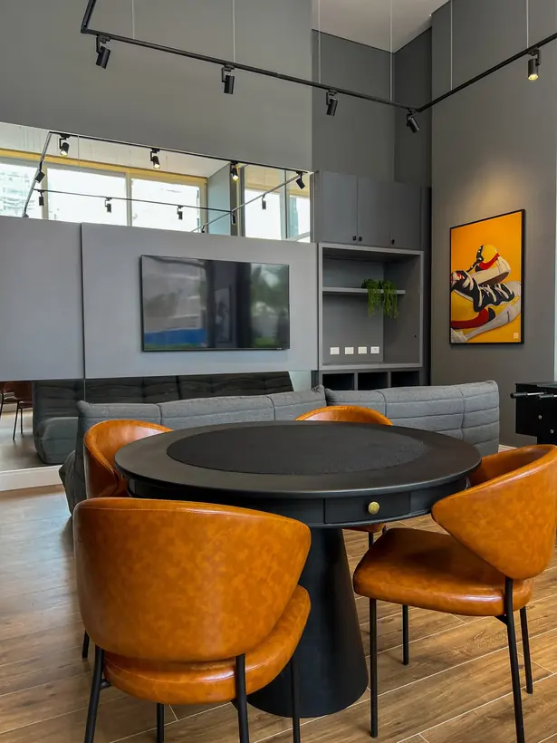 Sala de convivência com mesa central e poltronas