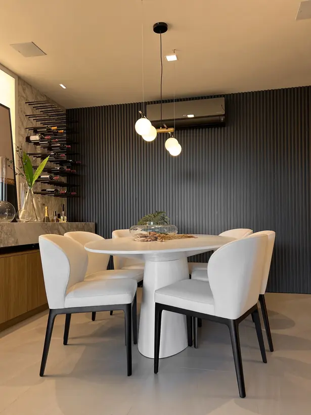Sala de jantar com mesa clara e iluminação pendente