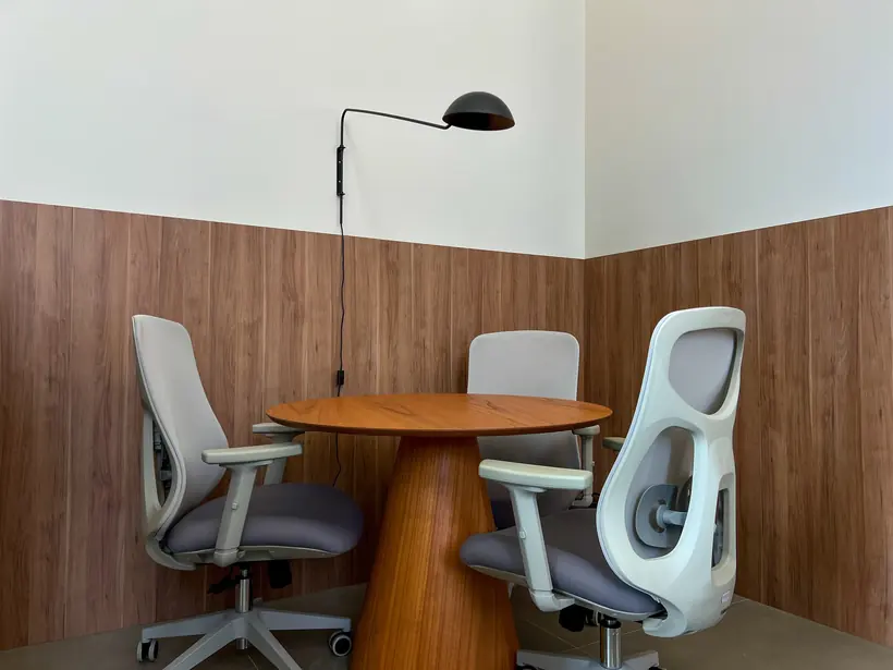Sala de reunião com mesa em madeira e cadeiras ergonômicas